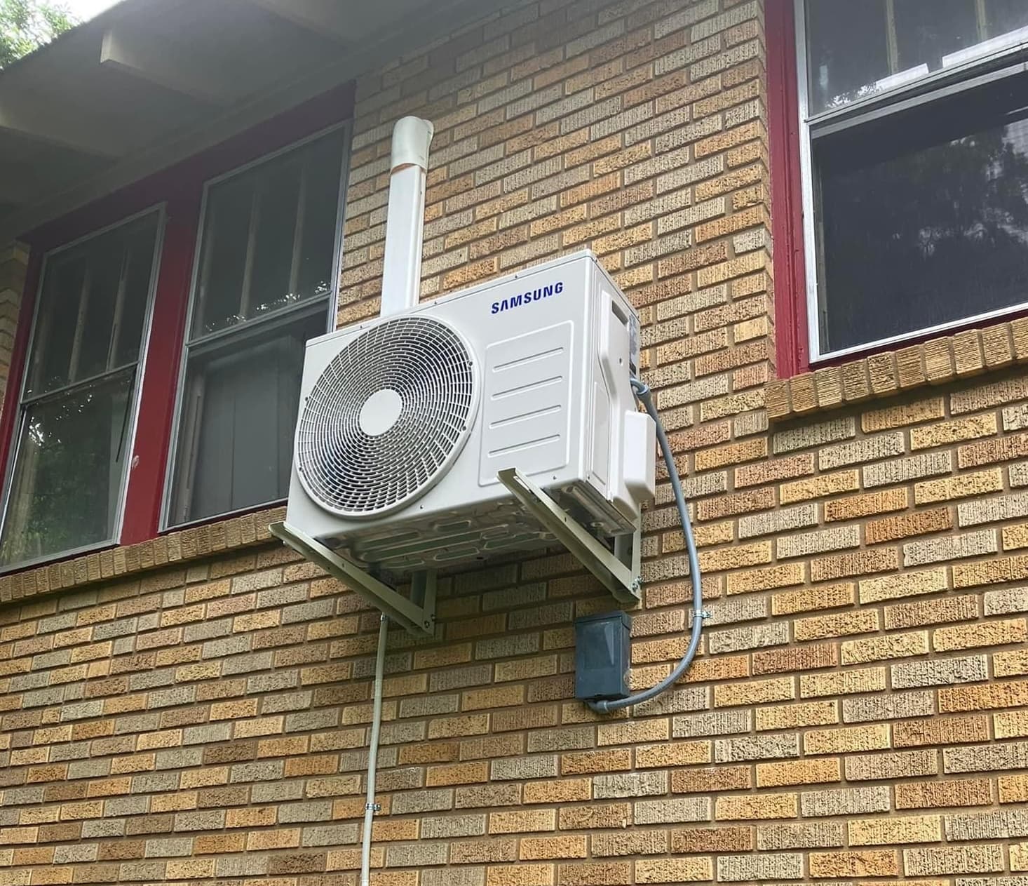 Samsung outdoor mini split unit mounted on the exterior wall of a building.